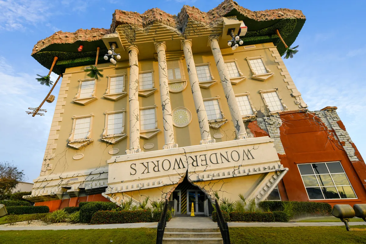 WonderWorks’ iconic upside-down building facade surrounded by tropical greenery and whimsical columns. The setting is playful, inviting guests to step into a world of curiosity and interactive fun.