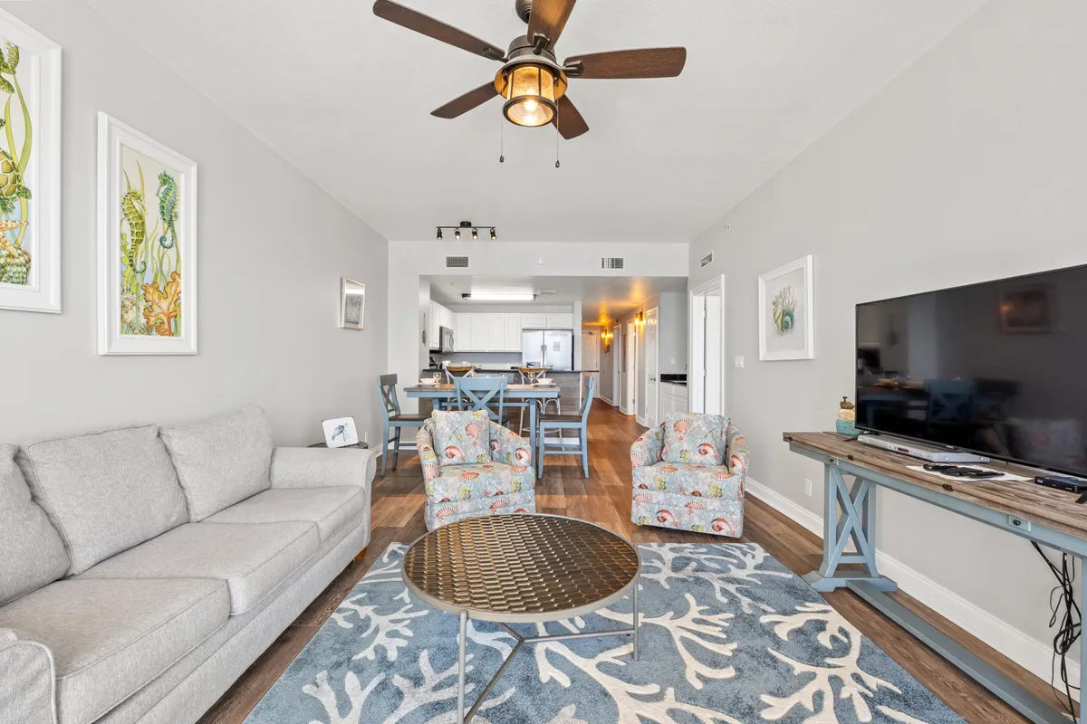 A cozy, casual living room with a sofa, armchairs, coffee table, television, and wall art. The space feels welcoming and perfect for group activities like movie nights or games, echoing the section’s focus on togetherness and comfort.